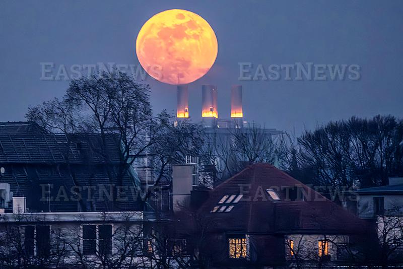 Der Vollmond geht abends um 18:30 Uhr uber dem Bavariaring auf, durch den Saharastaub in der Luft leuchtet er rotlich, Munchen, 3. Marz 2026